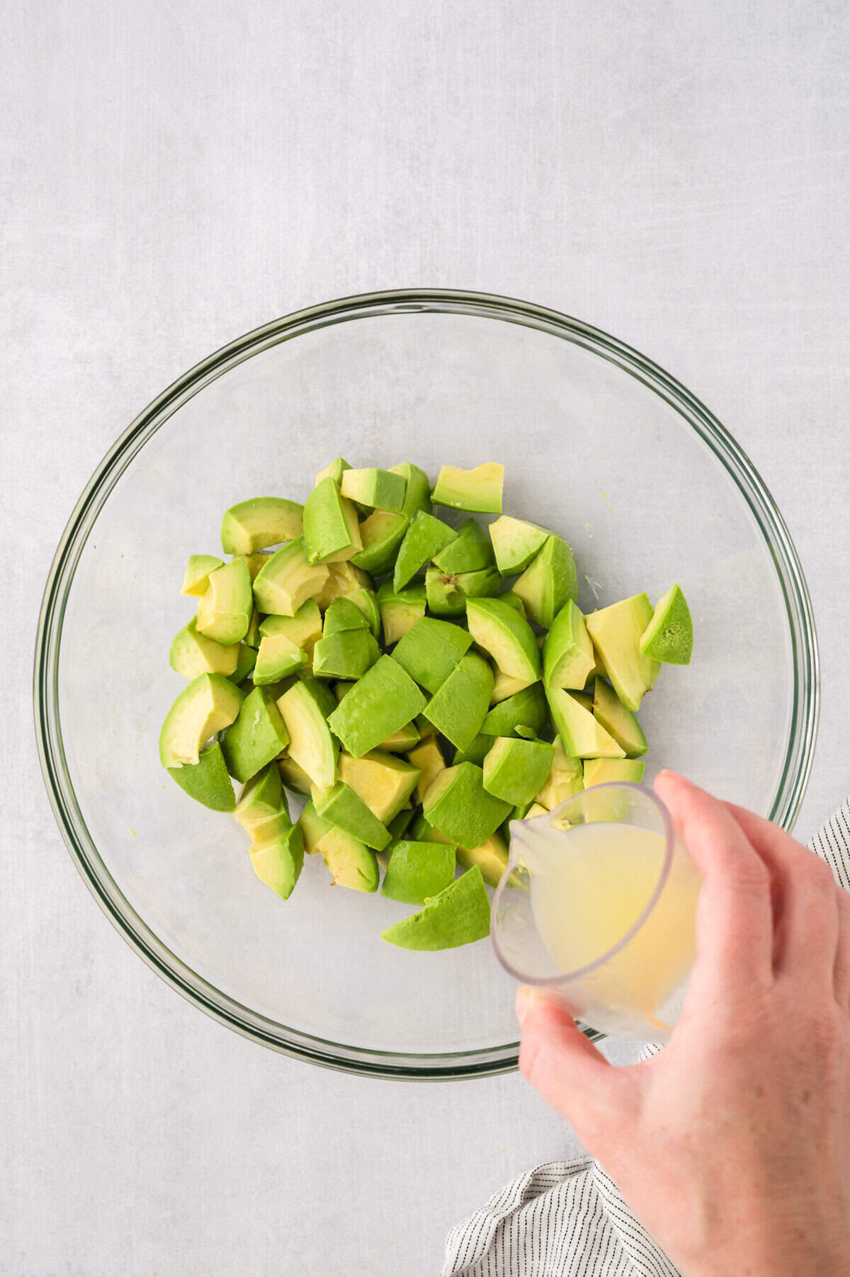 Lime juice being poured over avocado.