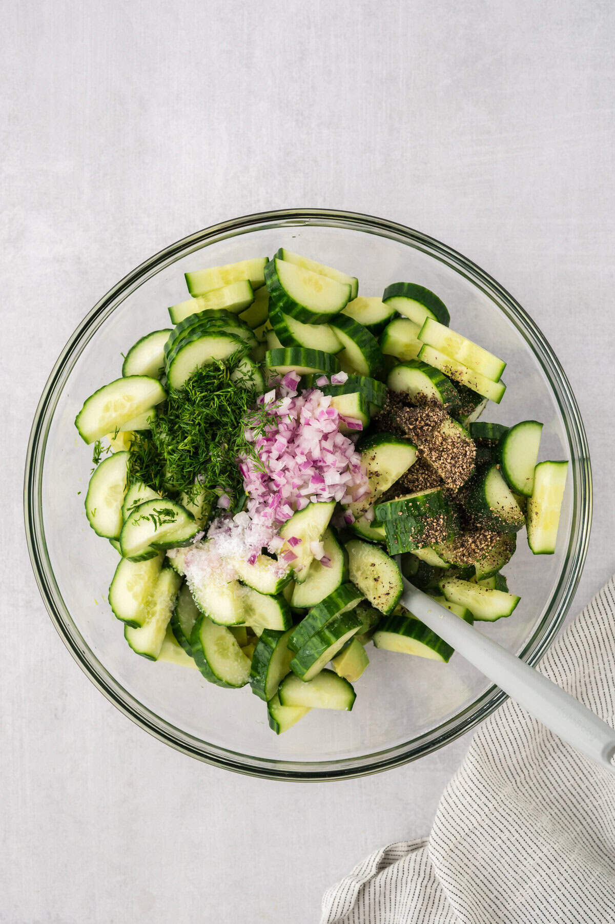 Ingredients for cucumber avocado salad in mixing bowl.