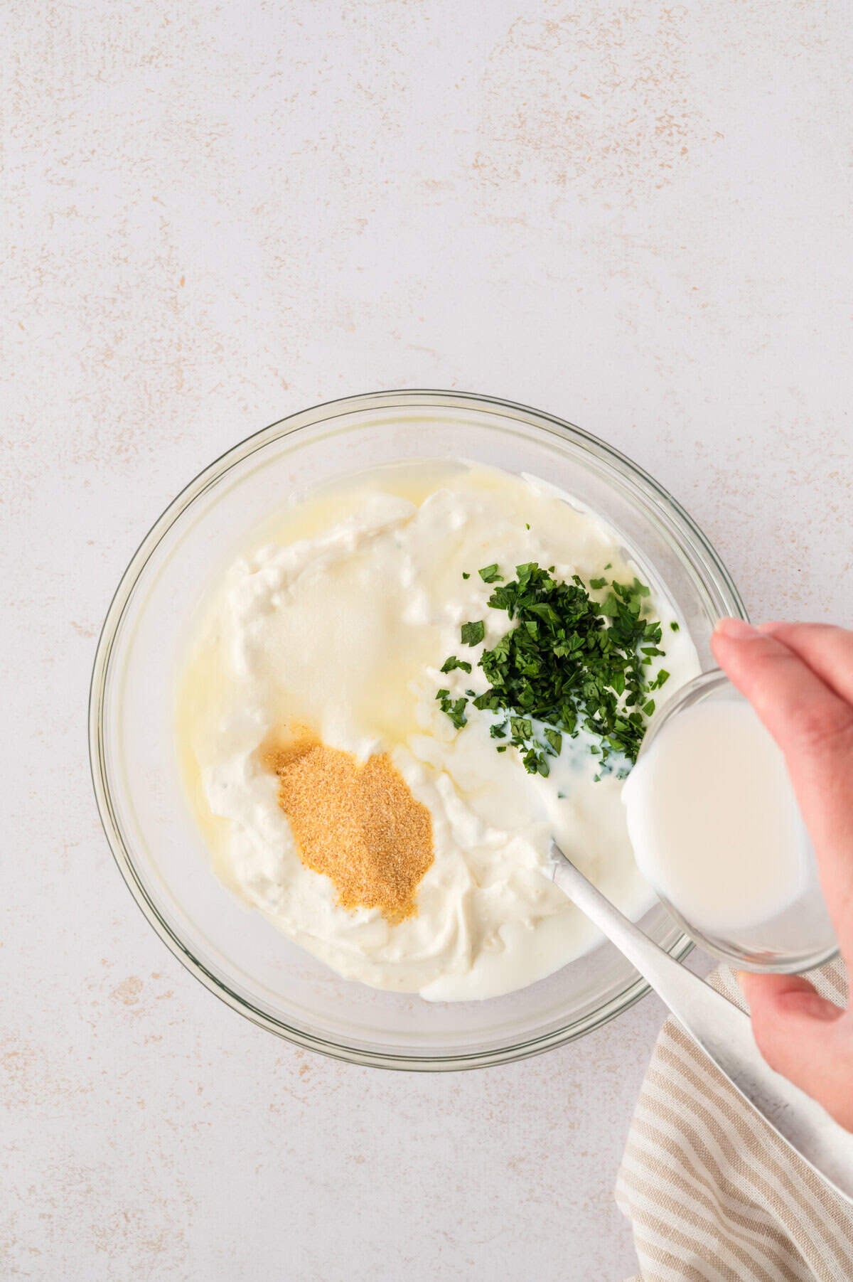 Milk being poured into keto blue cheese dressing.