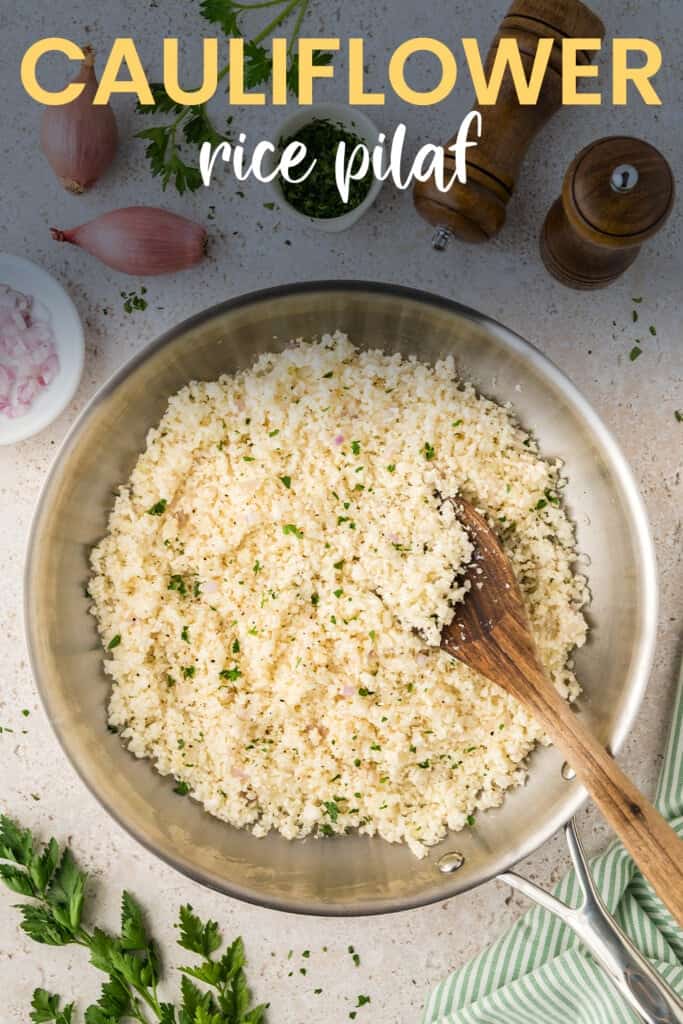 Skillet full of cauliflower rice with wooden spoon.