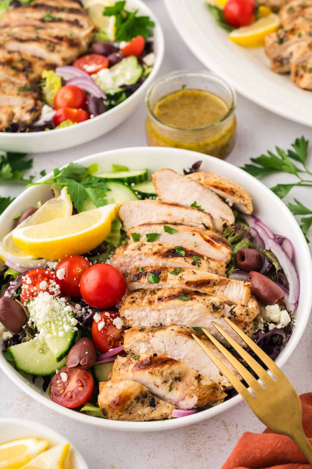 Greek grilled chicken on a green salad.