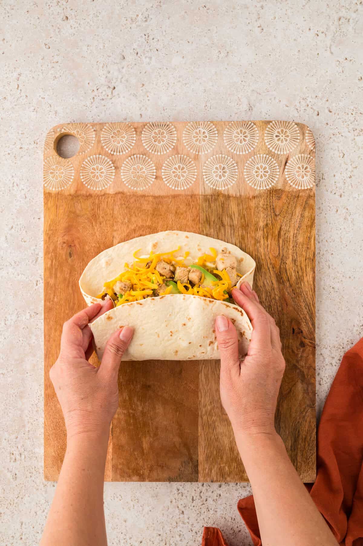 Rolling a chicken club wrap.