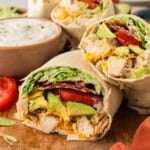 Low carb chicken club wraps on wooden board.