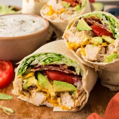 Low carb chicken club wraps on wooden board.