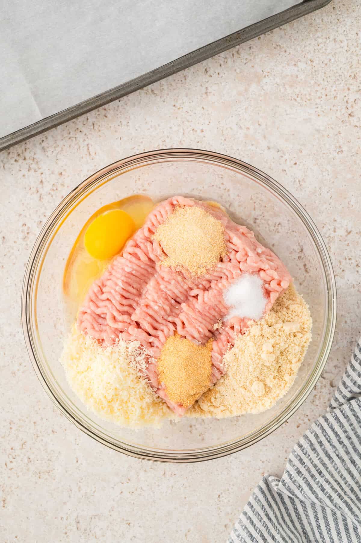 Ingredients for keto chicken meatballs in mixing bowl.