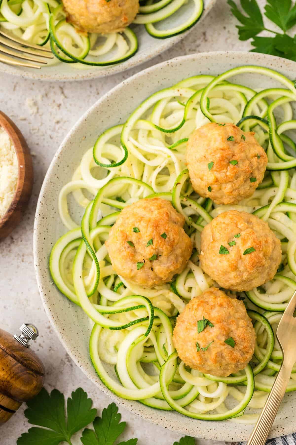 Keto chicken meatballs on pile of zucchini noodles.