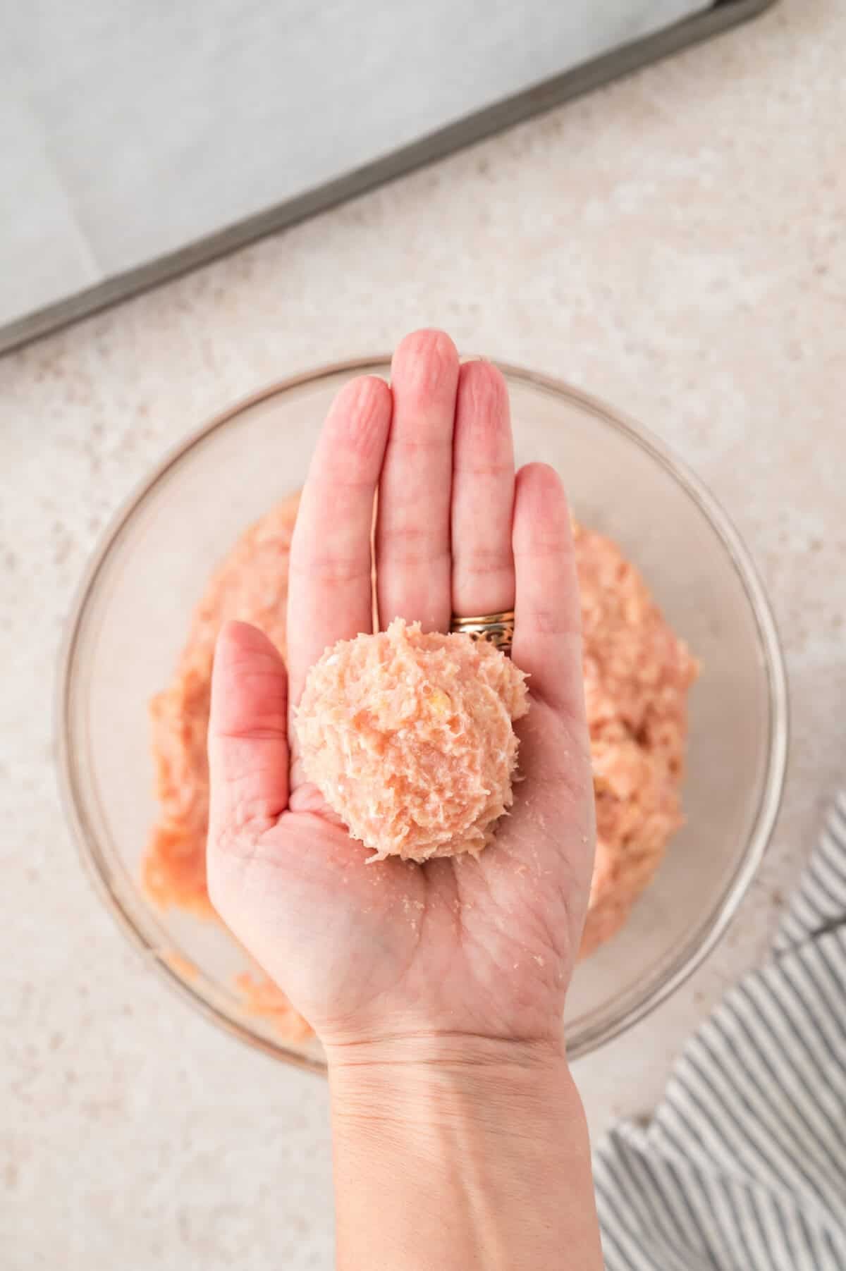Meatballs being rolled into balls.