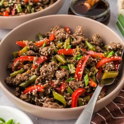 Bowl full of ground beef and vegetables with a fork.