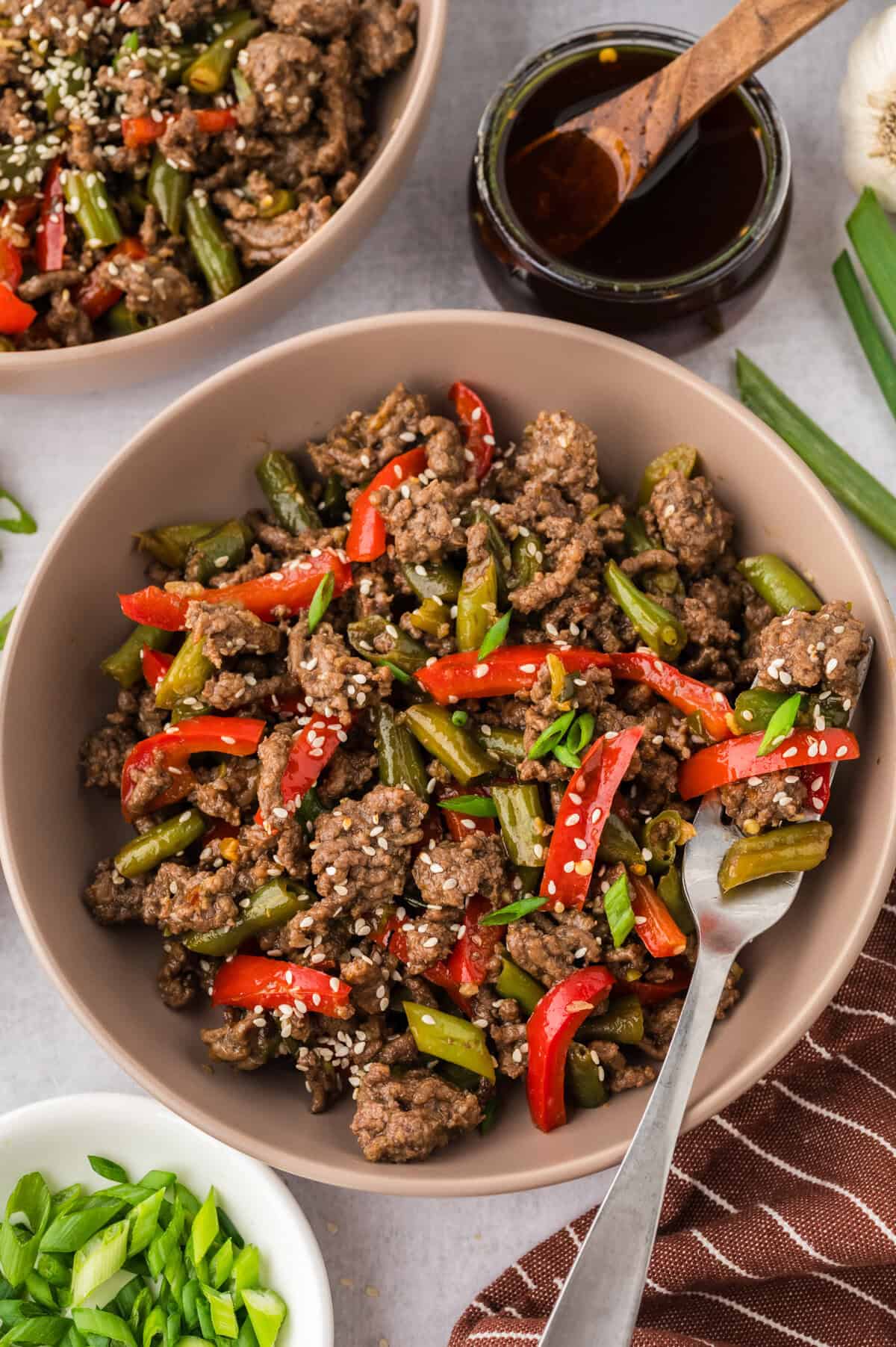 Bowl full of ground beef, peppers, and green beans in stir fry sauce.
