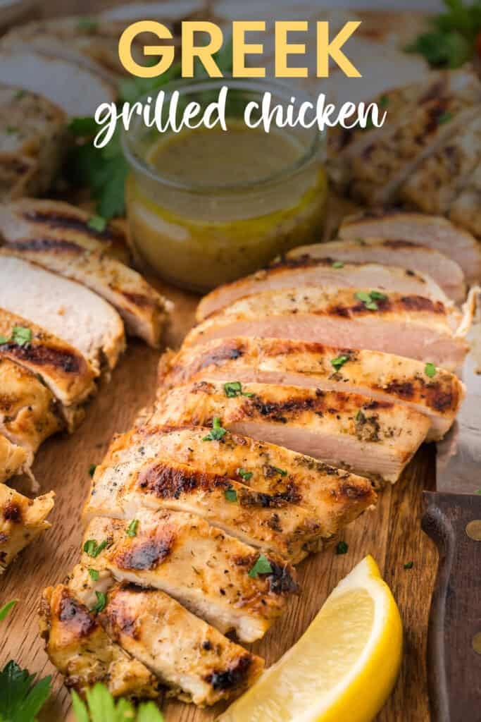 Sliced Greek chicken recipe on wooden board.