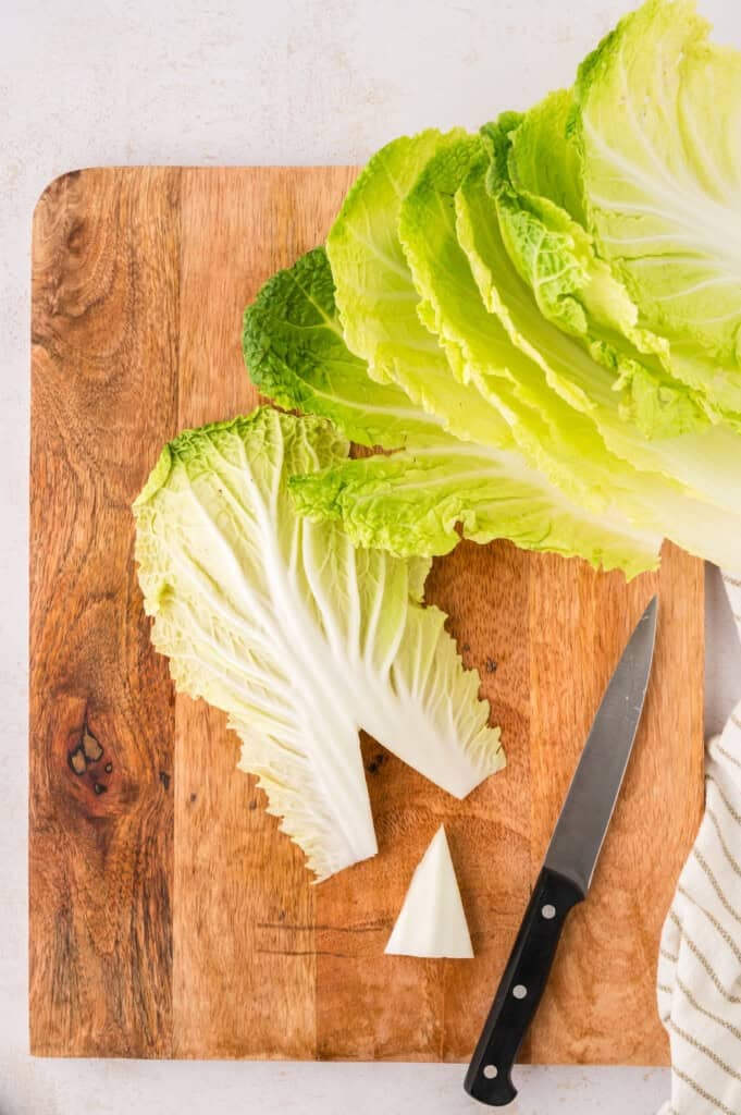 Napa cabbage leaves on cutting board.