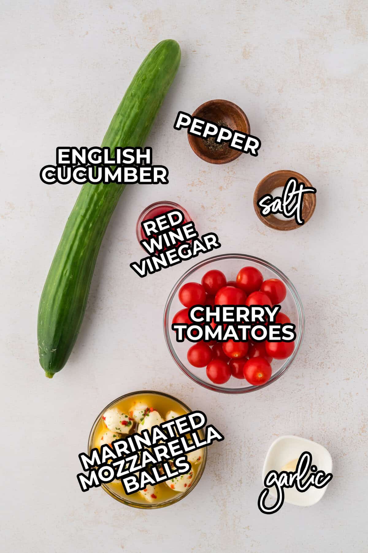 Ingredients for tomato cucumber salad with mozzarella balls.