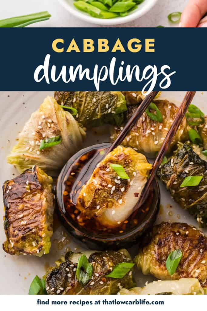 Cabbage dumpling being dipped in sauce.