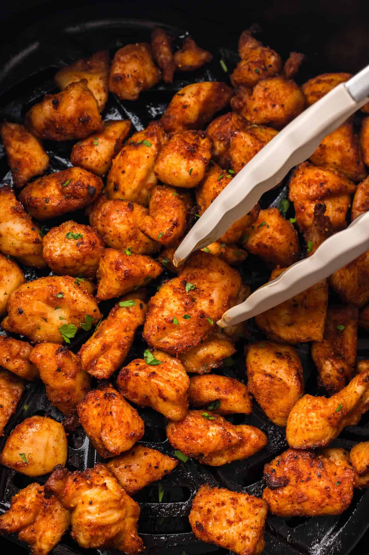 Keto chicken bites in air fryer basket.