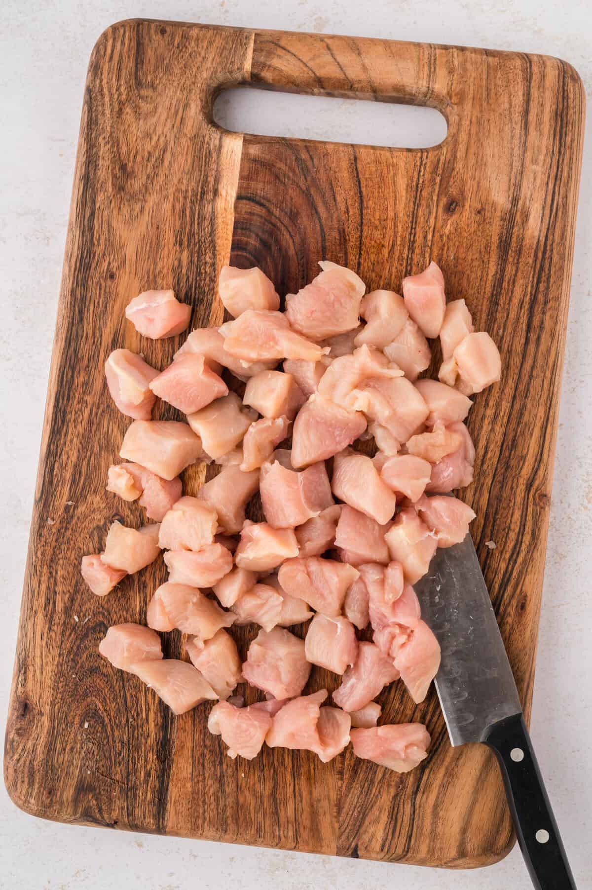 Diced chicken breast on cutting board.