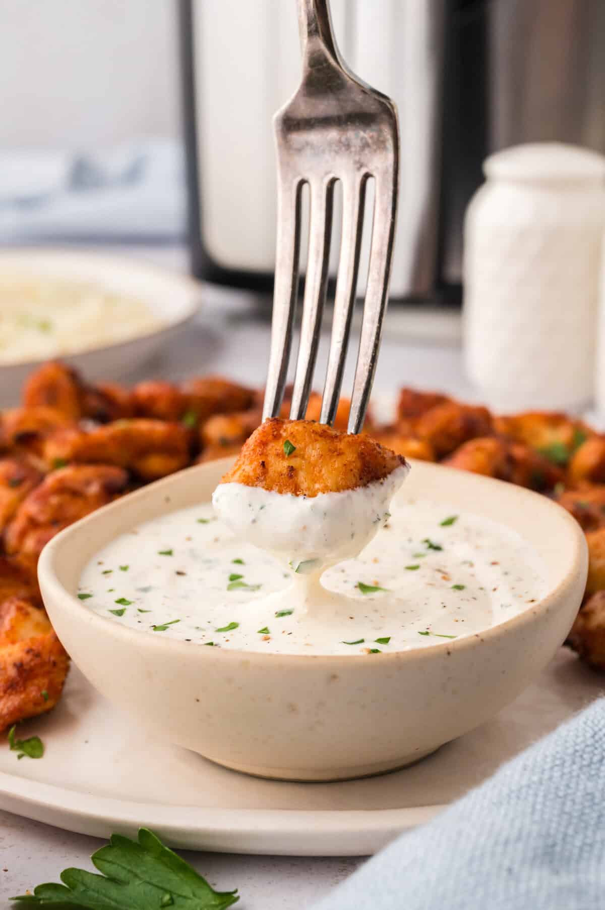 Chicken bite being dipped in ranch.