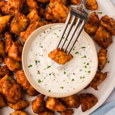 Chicken bite being dipped into ranch.