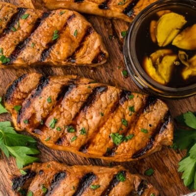 Grilled pork chops on cutting board.