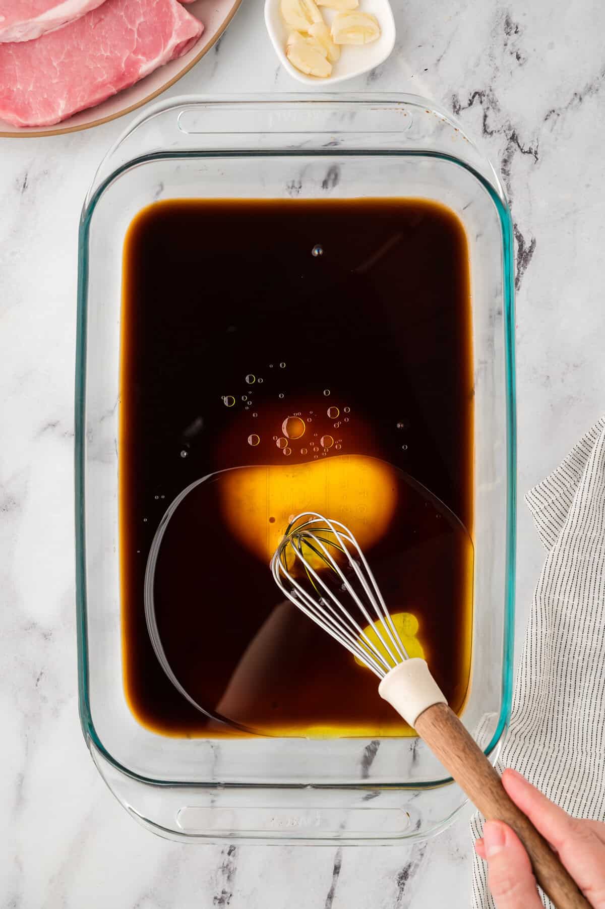 Ingredients for low carb pork chop marinade being whisked together in a baking dish.