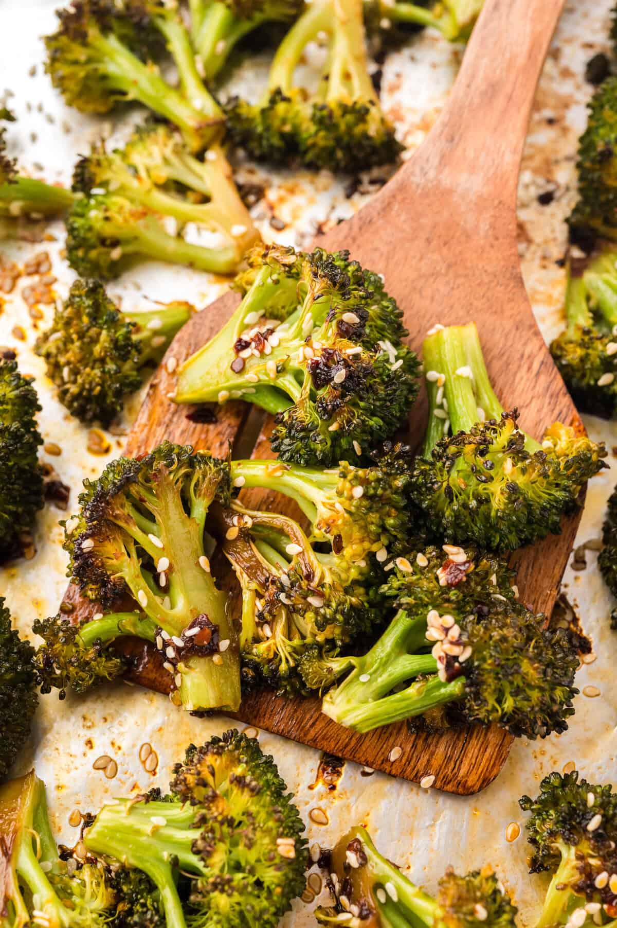 Asian broccoli on sheet pan with spatula.