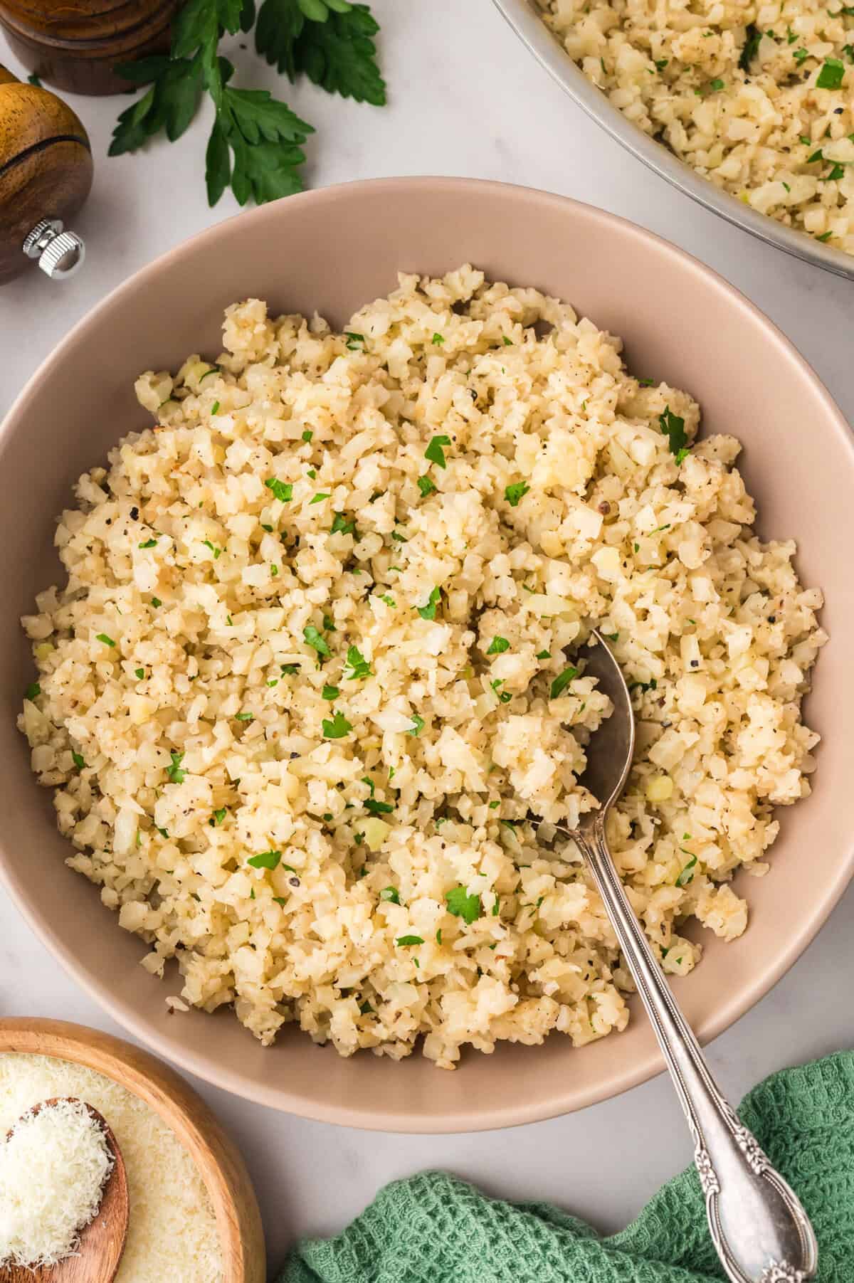 Bowl full of cauliflowre rice in a cacio e pepe sauce.