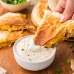 Chicken bacon ranch quesadilla being dipped into ranch dressing.