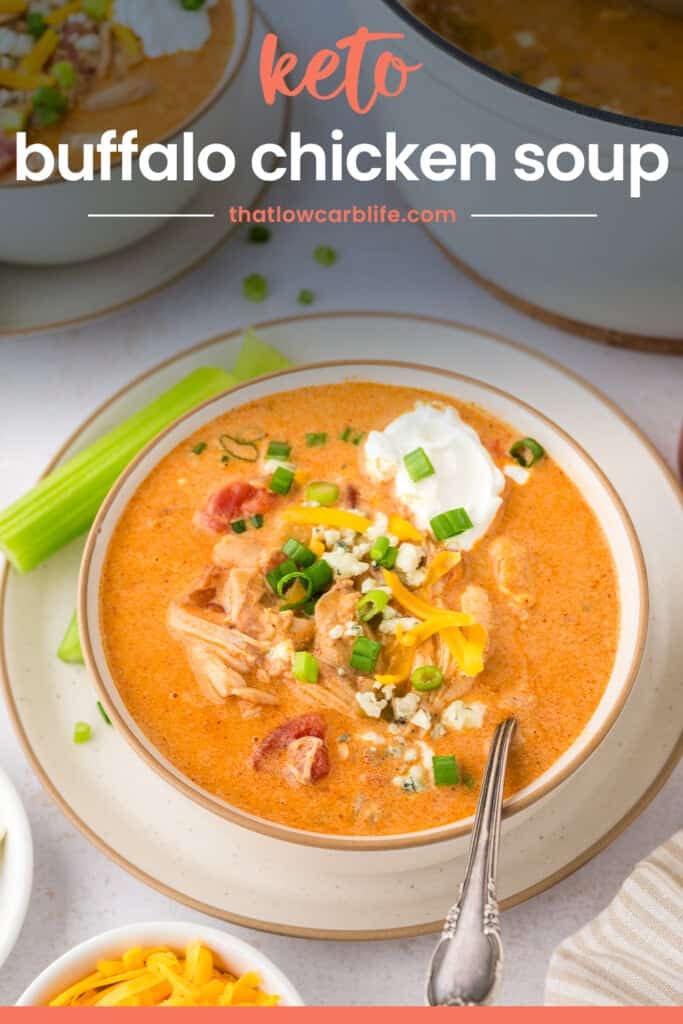 Buffalo chicken soup in a bowl, topped with sour cream, green onion, cheddar, and blue cheese.