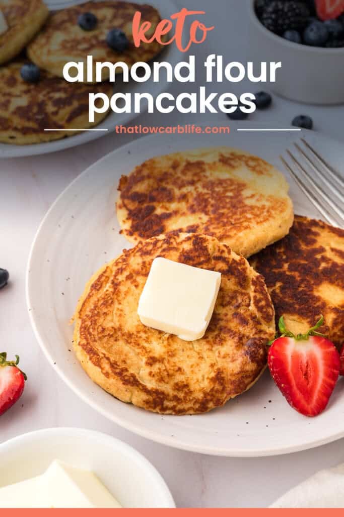 Keto pancakes on plate with butter and strawberries.