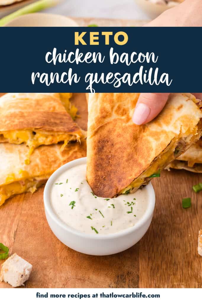 Hand dipping a quesadilla into ranch dressing.