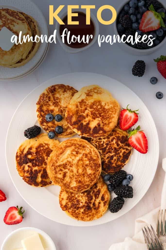 Low carb pancakes made with almond flour spread out on a plate with berries.