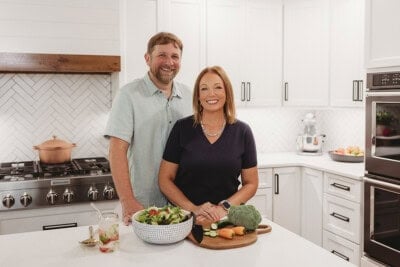 Chad and Karly, of thatlowcarblife.com, standing in their home kitchen.